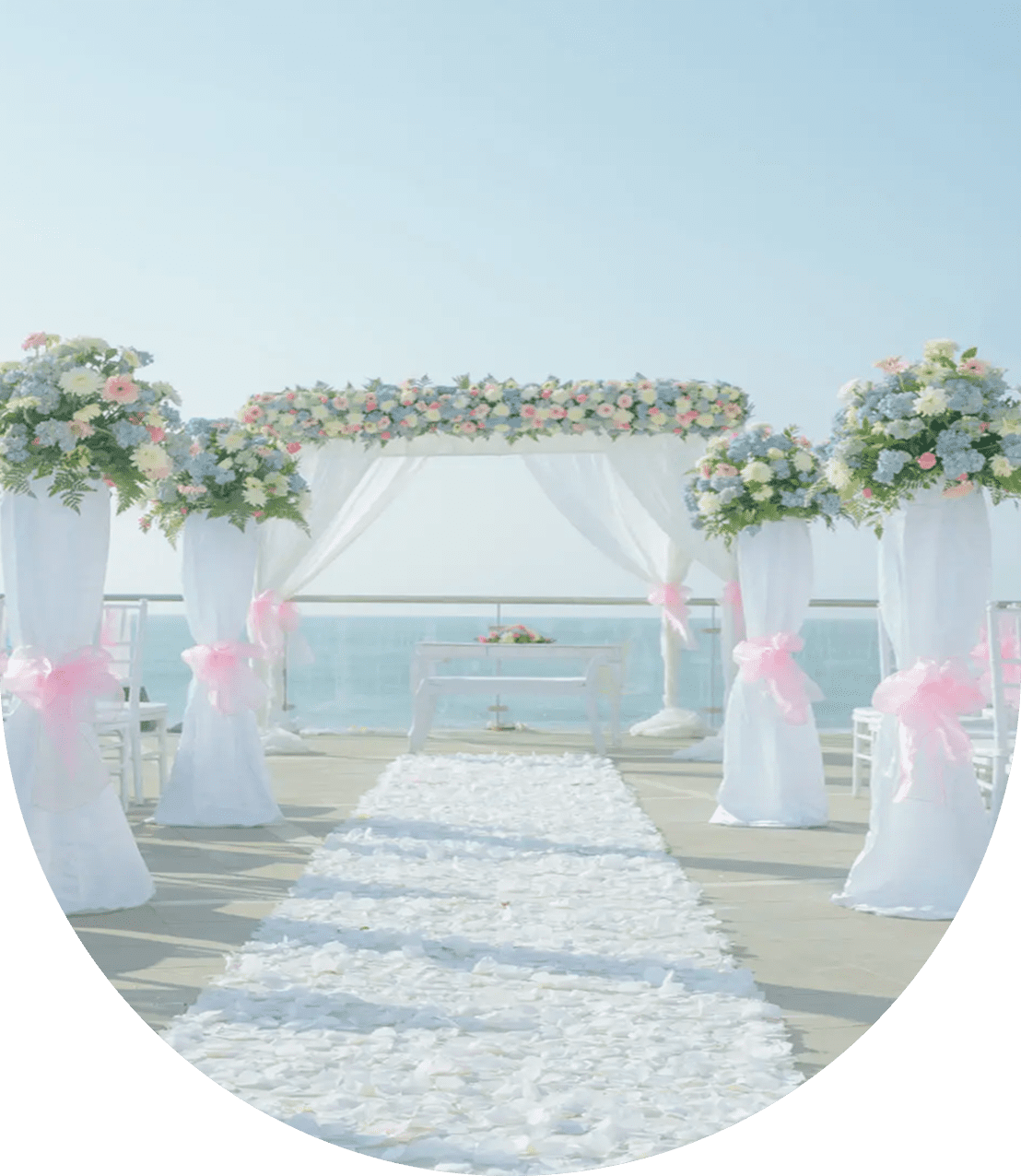 Elegant outdoor wedding setup by the sea with floral decorations.